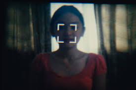 A young woman standing indoors in front of a window
